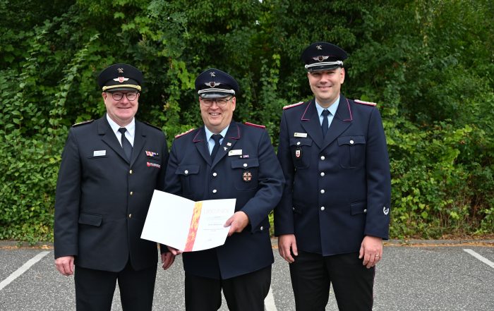Der Geehrte Arne Behrens mit Kreisverbandsvorsitzendem Jörn Petersen und Gemeindebrandmeister Hanstedt Sebastian Seier